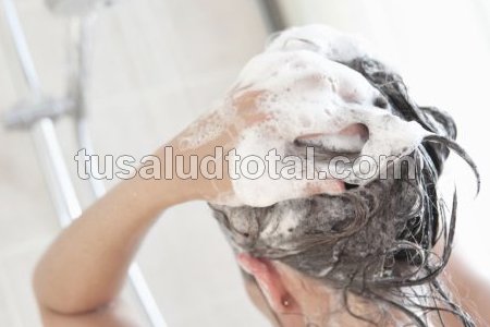 Mujer lavándose la cabeza (para prevenir espinillas capilares)